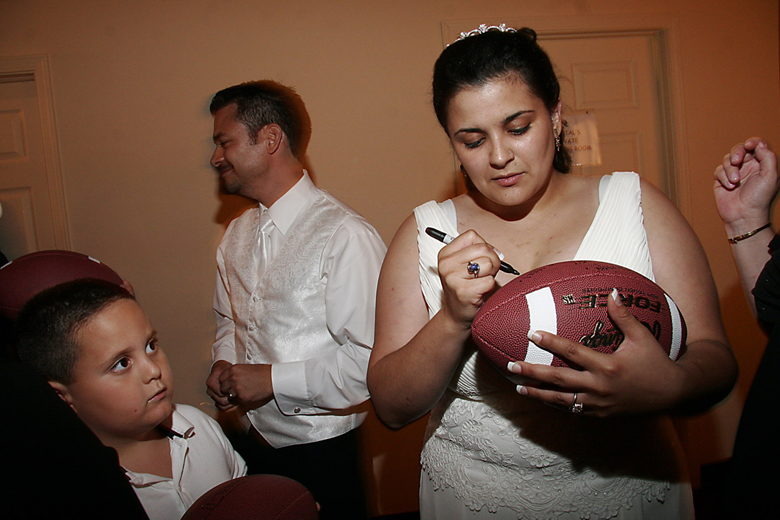 Bride signs the football at wedding recption